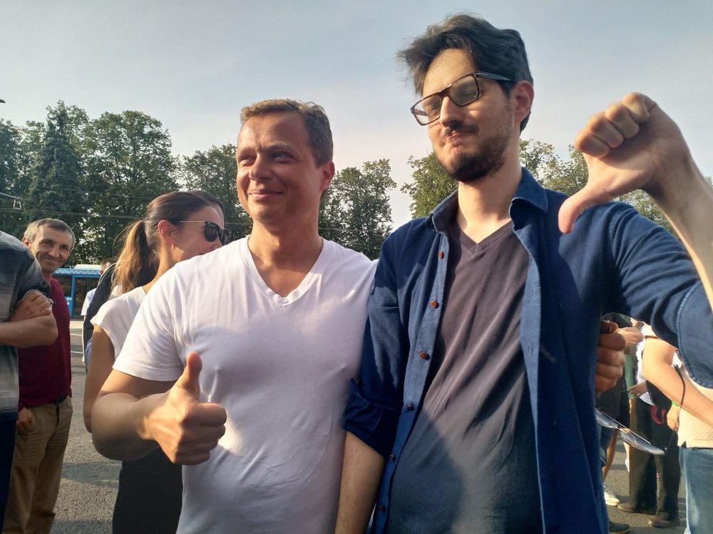 Na snímku z 1. září 2018, kdy se odehrála prezentace elektrobusů, se promenádoval i druhý hlavní zastánce likvidace trolejbusů, náměstek primátora Moskvy, Maksim Liksutov, a zároveň ředitel moskevského Odboru dopravy a rozvoje silničně-dopravní infrastruktury. Vedle něj se nachází politický aktivista Maksim Katz, který se snaží proti rušení trolejbusů bojovat a který také k nevoli radnice neúspěchy elektrobusů spolu se svým týmem dobrovolníků dosud monitoruje. Zatímco v září nebylo jasné, který z pánů vystihne další osud elektrobusů svým gestem lépe, po čtyřech měsících je celkem jasno. (foto: Gorodskije projekty)