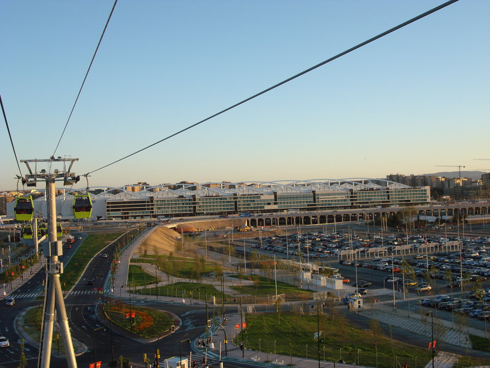 Pohled na intermodální stanici Delicias, kde se potkávají vysokorychlostní i konvenční vlakové spoje, ale i autobusy. Jedná se o pozoruhodnou, nicméně ne praktickou stavbu, která si vyžádala obří investici. Vzhledem k tomu, že nedaleký výstavní areál dopomohl nejen k lepšímu obrazu města, ale i kapsám politiků a jim spřátelených osob, a pak po třech měsících slávy začal vadnout, neváhaly některé noviny přijít s články typu 