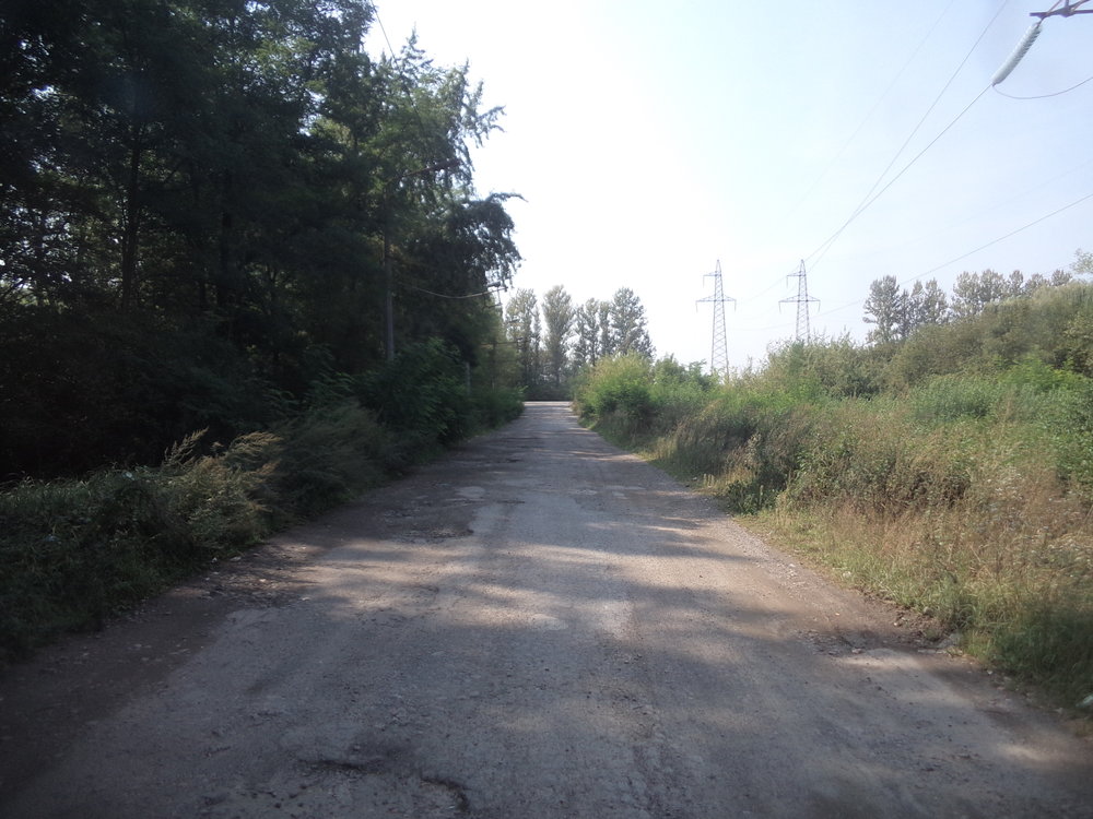 V dáli lze zahlédnout silnici H09 Ivano-Frankivsk – Lvov a k ní směřující rozbitá cesta je ...