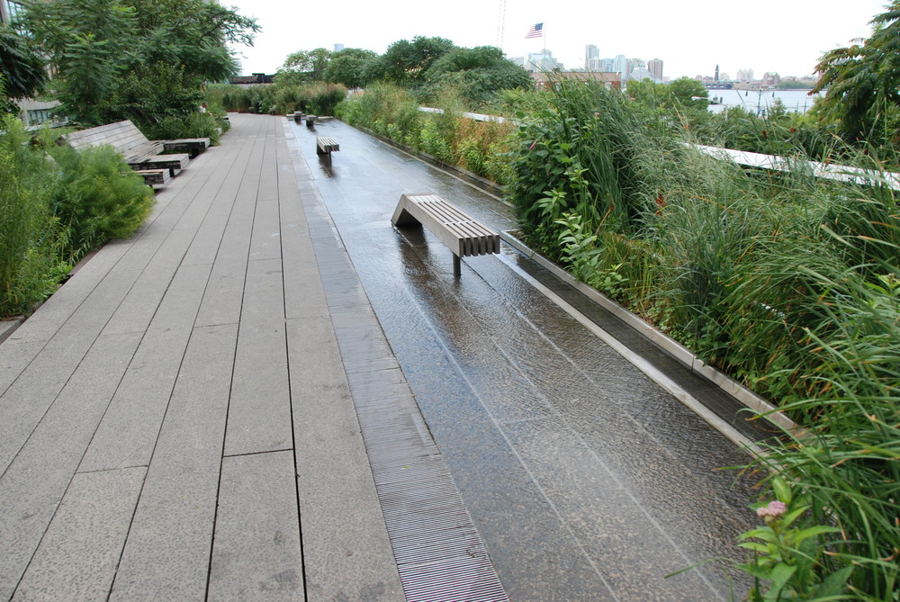 Tato část High Line patří mezi nejpopulárnější, a to nejen pro možnost procházky v tekoucí vodě. Jedná se o široký prostor (za zalení napravo se nachází další část High Line s další zelení) v blízkosti občerstvení, toalet a s možností využití lehátek (na levé straně fotografie), odkud můžete pozorovat řeku Hudson a New Jersey. (foto: Libor Hinčica)