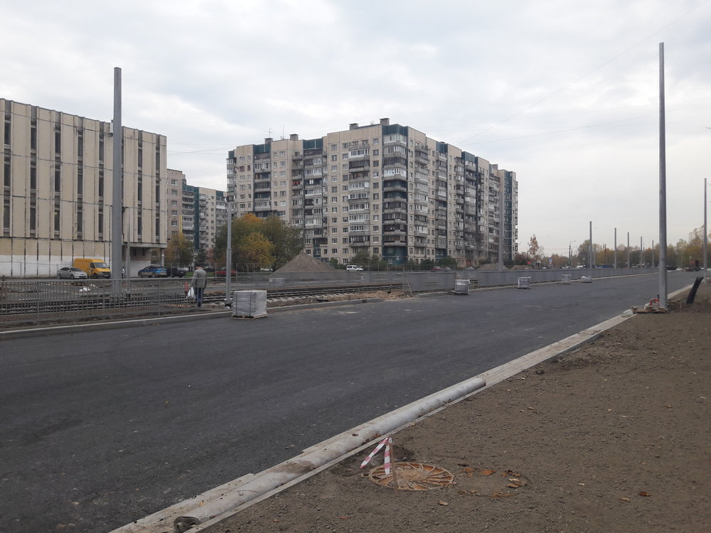  Procházka od Irinovskogo prospekta k prospektu Kosygina po prospektu Nastavnikov. Zde pohled směrem na sever. Tam, kde končí sloupy, jsou položeny dvě výhybky pro obrat  čižiků , kteří sem začnou jezdit ještě v tomto roce. Tramvajová trať, po které jezdí městské tramvaje linek 7 a 10, není na snímku příliš vidět, je totiž v pozadí, brzy ale začne být také přestavována. 