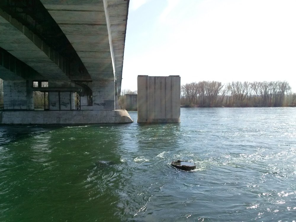V minulosti byla tramvajová síť v Usť-Kamenogorsku mnohem větší, než tomu bylo v posledních letech. Za sovětských časů přitom ještě existovaly mnohé smělé plány, například na rozšíření tramvají k letišti ležícímu severozápadně od centra. Jeden z návrhů předpokládal i překročení Irtyše a zavedení tramvajové dopravy na levém břehu této významné řeky (centrum a většina města se rozkládá na pravém břehu řeky). Výstavba mostu pro tramvajovou dopravu byla opravdu spuštěna a taktéž došlo na levém břehu i k pokládce některých kolejí. Jenže peníze se s blížícím se rozpadem SSSR kutálely směrem k projektu čím dál méně, až se práce nakonec zastavily. Po privatizaci tramvajové dopravy v polovině 90. let došlo k rozhodnutí koleje a některé další komponenty připravované trati vytrhat a prodat a v místě nedokončeného tramvajového mostu byl vztyčen most automobilový. Jako památka zůstaly některé opory. Snímek je z roku 2014. (foto: Valerij Kozlov)