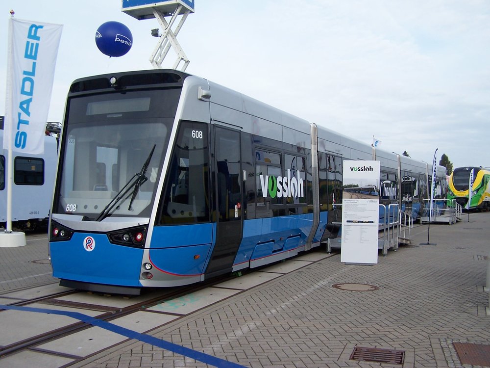 Tramvaje s podobným řešením, jaké dnes poptávají Drážďany, pořídil také německý Rostock od španělského Vosslohu (dnes součást Stadleru). Na fotografii je rozšíření vozové skříně až nad hranou nástupiště dobře patrné zejména při pohledu na dveře. (zdroj: Wikipedia.org)