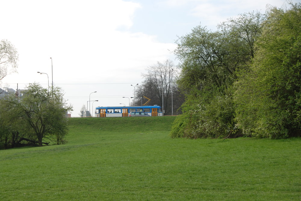 Opačný pohled než na předchozí fotografii. Z tohoto snímku je zřetelný značný výškový rozdíl mezi koridorem vyhrazeným pro tramvaj, a vyvýšeným náspem ulice Opavské, po němž právě projíždí vůz typové řady T3. Ve svahu měl začínat/končit tunel prvního podzemního úseku ostravské tramvaje, který se nikdy nerealizoval. (foto: Libor Hinčica)