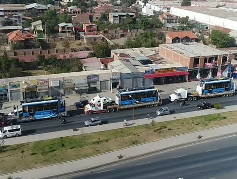 Tramvaj byla rozložena na tři části a uložena do kontejnerů typu flat rack od společnosti Maersk. Vypravena byla z Minsku první červencový týden, z litevského přístavu Klaipėda odplula téhož měsíce a na své 40denní pouti mimo jiné proplula i Panamským průplavem. Do severochilského přístavu Iquique dorazila dne 6. 9. 2019. Po téměř celou cestu byly články tramvaje zabaleny do “peřiny” v podobě bílé ochranné fólie, na snímku je již vidíme ale odhalené. Bylo slibováno, že z Iquique tramvají dorazí za 48 hodin do Cochabamby, nicméně tento optimistický odhad se naplnit nepodařilo. Dodejme, že se nejedná o tutéž tramvaj, která byla poslána v červenci na vybrané homologační zkoušky do polského Olsztynu. (foto: Mi Tren Cochabamba)