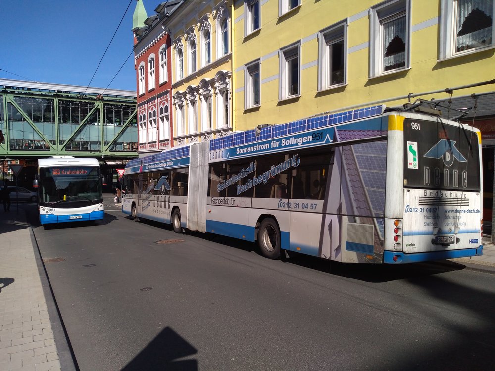  Na snímku vidíme na pravé straně trolejbus, který přijel ze Solingenu. Zahne doprava a pak doleva, aby dojel k vohwinkelskému nádraží. Sběrače – v souladu s tím, co bylo psáno o několik snímků dříve – shodil ještě před příjezdem na blokovou smyčku: musel, na snímku viditelná stopa je totiž určená pouze protisměrně jedoucím trolejbusům. Ty se ale natrolejují těsně před výjezdem ze smyčky.  