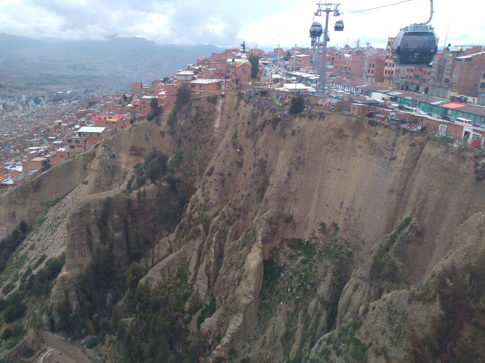  Stříbrná linka lanovky se vznáší nad údolím, v tomto momentě se už nachází nad katastrem La Pazu (ten je vlevo). 