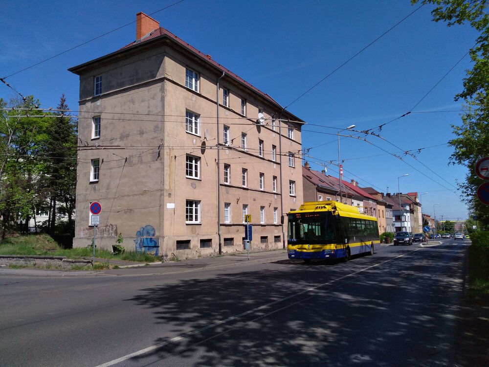 Zde vidíme trolejbus na Duchcovské ulici, jak dokončuje sklápění sběračů a plynule pokračuje v jízdě do nedalekého Hudcova.