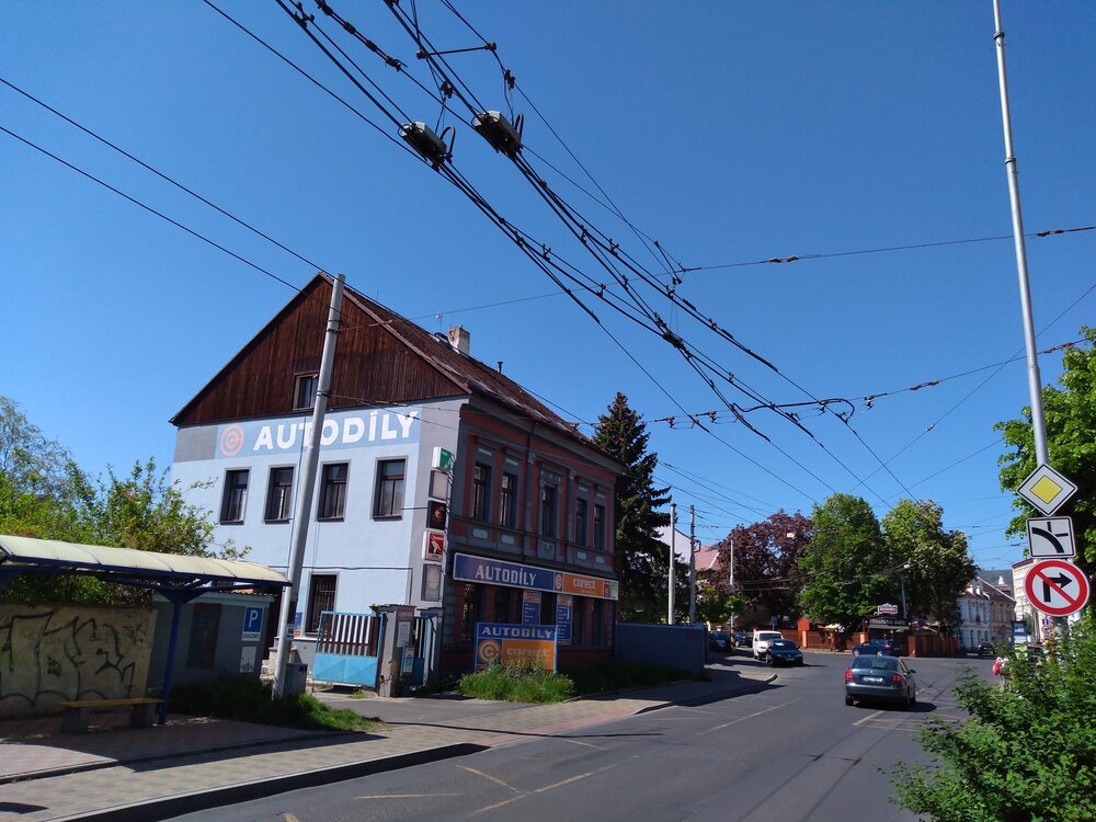  Galerii trati, která má být částečně snesena, začínáme na konci ulice U Červeného kostela. Zde se trať přicházející ve směru od centra větví. Vlevo pokračují dvě stopy k vozovně, vpravo na ulici Zemskou. Za zády fotografy se nachází onen kostel, jak ukazuje následující snímek.  