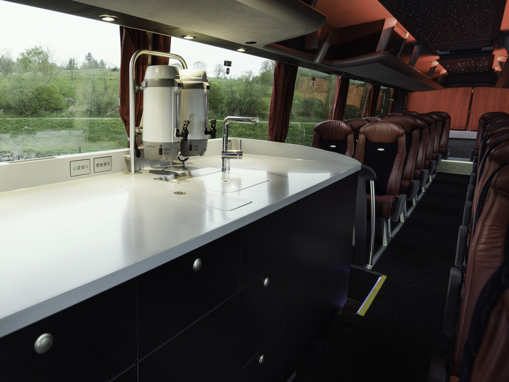 Moderní kuchyňský pult před druhými dveřmi se světleným logem v pracovní desce. (foto: MAN Truck & Bus)