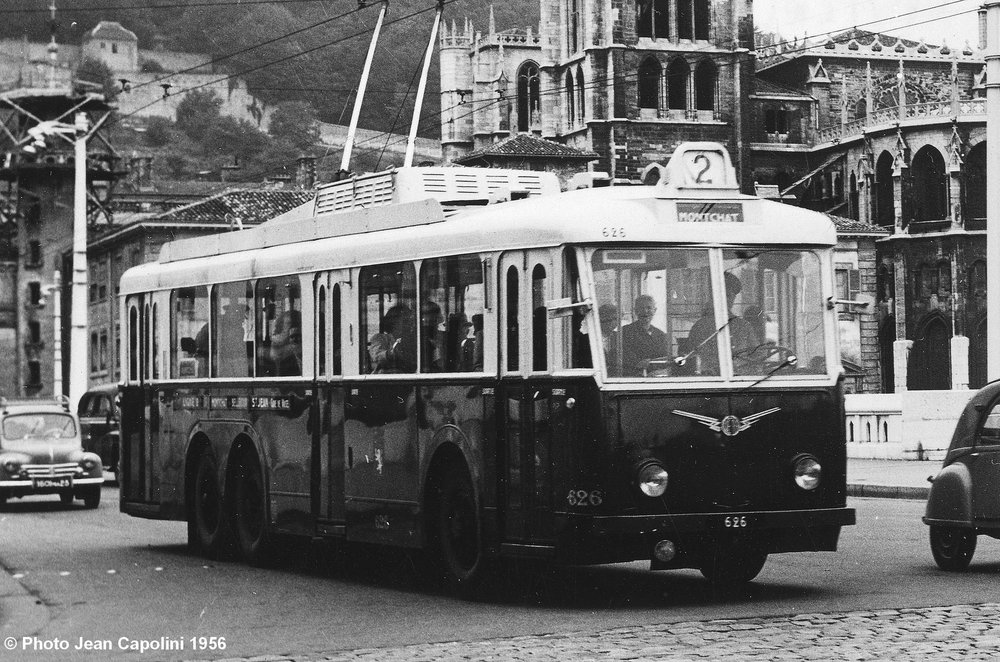 Lyonský vůz typu VA3 ev. č. 626 na lince č. 2 ve směru Montchat byl zachycen v srpnu 1956 na mostě Bonaparte s katedrálou St-Jean Baptiste v pozadí. Povšimněte si odporníků namontovaných na střechu, díky čemuž mohl být v zimě do salónu cestujících vháněn teplý vzduch. (foto: Jean Capolini)