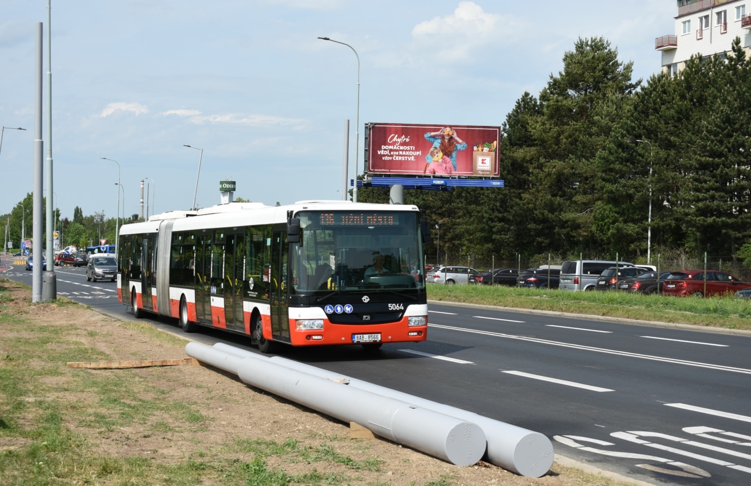 Autobus SOR NB 18 CITY linky číslo 136 projíždí kolem sloupů budoucí první pražské trolejbusové linky č. 58 z Čakovic na Prosek. Pokud by došlo k elektrifikaci linky číslo 136 (v kombinaci s linkou číslo 150), byl by nyní budovaný úsek pochopitelně využíván i linkou č. 136. (foto: Libor Hinčica)